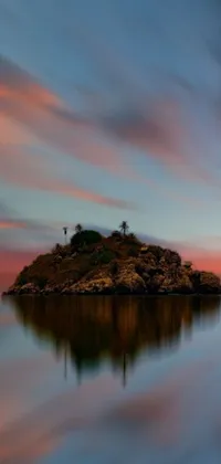 This phone live wallpaper depicts a serene sunset scene with a small island in the midst of calming waters