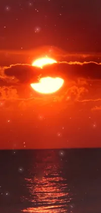 This phone live wallpaper showcases a breathtaking sunset over a body of water