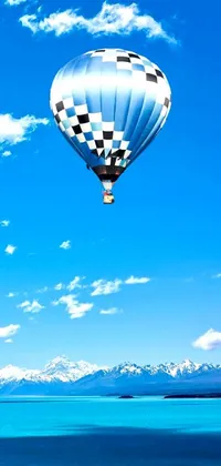 This phone live wallpaper features a stunning hot air balloon set against a sky blue and white geometric background