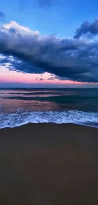 This beautiful live wallpaper captures the tranquility of a calm ocean beach at dusk