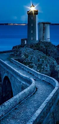 This phone live wallpaper depicts a majestic lighthouse perched on a cliff next to the ocean