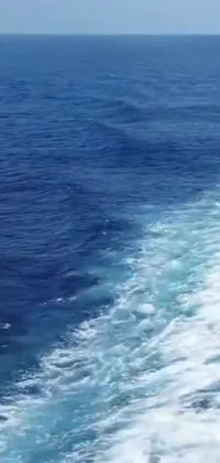 Introducing a stunning live wallpaper for your phone, featuring an awe-inspiring view of the ocean from the back of a boat