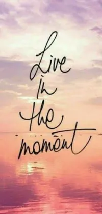 This lively phone wallpaper showcases a colorful sunset with casual cursive fonts spelling "live in the moment"