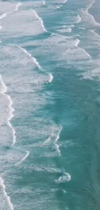 This Phone Live Wallpaper features a stunning ocean view of a surfer riding a wave on a beach
