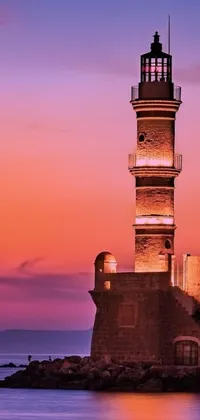 This live phone wallpaper showcases a breathtaking lighthouse surrounded by calm waters at sunset in old town Mardin