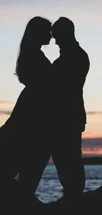 This phone live wallpaper features a stunning black silhouette of a couple embracing in a passionate kiss