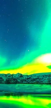 This live wallpaper boasts a vibrant display of green and yellow aurora borealis over a tranquil body of water during winter