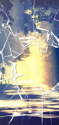 This phone live wallpaper features an abstract digital art piece, showcasing a shattered glass window against a stunning sunset backdrop