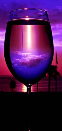 This phone live wallpaper showcases a beautiful glass of wine on a wooden table with a picture in the background