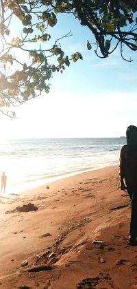 This live wallpaper for your phone showcases a man skateboarding on a sandy beach against a backdrop of beach trees in Indonesia