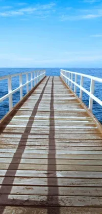 Transform your phone screen with a peaceful wooden pier extending to the endless blue waters of an ocean