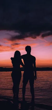 This live wallpaper features a romantic scene of a couple standing on a beach at sunset