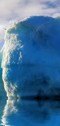 This phone live wallpaper showcases an extraordinary image of a giant iceberg in the center of a calm body of water