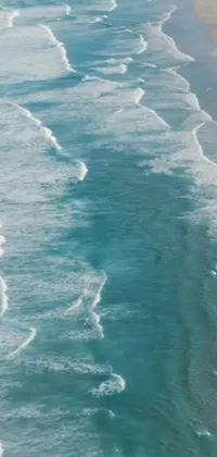 Enjoy the serene and exciting scenery of the beach with this stunning phone live wallpaper