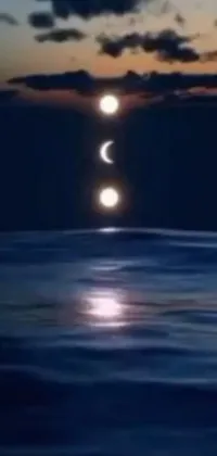 This live wallpaper showcases a surreal scene of three eclipses in the sky over a body of water