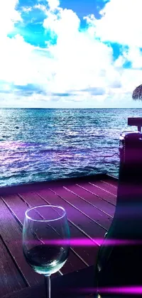 This phone live wallpaper showcases a stunning view of the Maldives, featuring a bottle of wine on a wooden table, surrounded by trendy fashion items