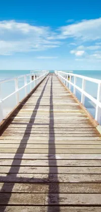 This live wallpaper showcases a gorgeous beach scene with a long wooden pier that extends into the crystal clear turquoise ocean
