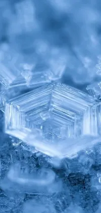 This live wallpaper features a stunning macro photograph of a snowflake on top of an ice pile