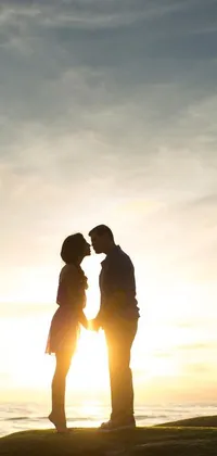 This live phone wallpaper depicts a couple standing on a hill, basking in the warmth of a sunlit sky