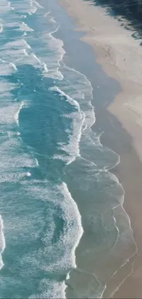 Looking for an exciting and captivating live wallpaper for your phone? Check out this high-quality image featuring a breath-taking body of water next to a beautiful sandy beach