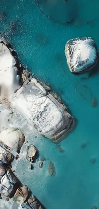 Adorn your phone with a spectacular live wallpaper of rocks atop serene waters