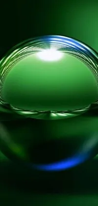 This phone live wallpaper features intricate digital art of a green blessing, a symbol of good fortune and prosperity, on a glossy glass sphere