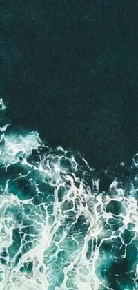 This stunning phone live wallpaper depicts a surfer riding the waves in the middle of the ocean