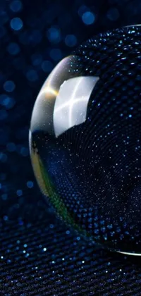 This live wallpaper showcases a digital glass ball on a table, displaying a cosmic entity formed by stars against a dark blue background