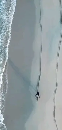 Transform your phone screen with a stunning live wallpaper featuring a skilled surfer riding the waves of a crystal-clear beach