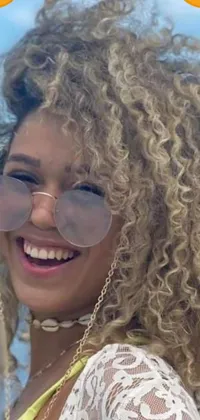This phone live wallpaper showcases a cheerful woman with glasses and curly blond hair posing in front of a vintage renaissance-inspired album cover