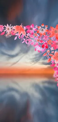 This beautiful digital painting of flowers with a stunning sunset in the background is perfect for your phone's live wallpaper