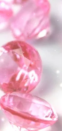 Get mesmerized by this live wallpaper featuring pink diamonds arranged in an artistic manner on top of a table