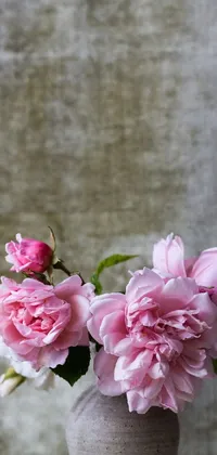 This phone live wallpaper features a stunning still life scene with a vase filled with pink flowers on a grey background