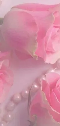 This phone live wallpaper features a digital rendering of three pink roses and pearl necklace against a white background