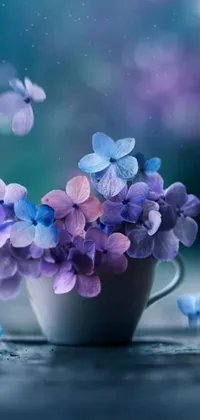 Bring your phone screen to life with this stunning live wallpaper featuring a vibrant cup filled with purple and blue flowers in different seasons - spring, summer, fall, and winter