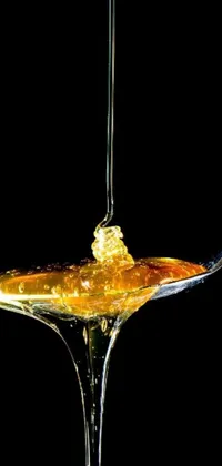 This live wallpaper features a stunning spoon covered in honey, with fluid maple syrup flowing down the handle