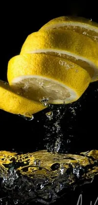 This phone live wallpaper showcases a slice of lemon as it falls delicately into a pool of crystal-clear water, producing a mesmerizing ripple effect