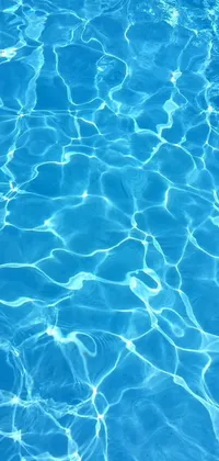 Looking for a stunning phone live wallpaper? Look no further than this beautiful image featuring a serene pool with crystal clear, blue water! The pale blue backlight of an iPhone background adds to the overall look and feel of the wallpaper, creating a visual masterpiece that's perfect for summertime