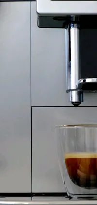 This phone live wallpaper depicts a cup of coffee on a modern counter beside a coffee machine
