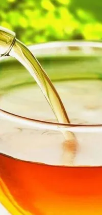 This live phone wallpaper displays a serene and peaceful image of green tea being poured into a glass cup