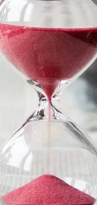 This phone live wallpaper features an hourglass atop a newspaper with a captivating photo from Pixabay in the background