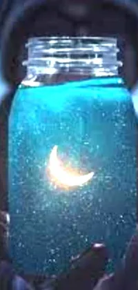 This phone live wallpaper features an enchanting image of a jar containing a glowing, blueish moon in water