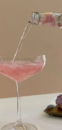 This captivating live wallpaper showcases a mesmerizing pink drink being poured into a tall glass
