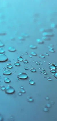 This live wallpaper backdrop depicts water droplets on a surface, with a vibrant blue background and a photo-realistic render by a talented artist