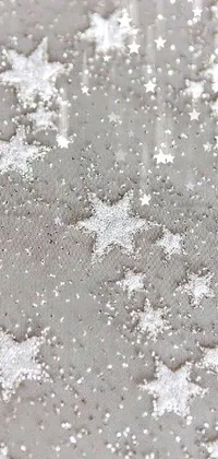 This phone live wallpaper displays a close up of snow flakes on a stipple surface, in a silver background