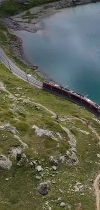 This phone live wallpaper displays a serene mountain landscape with a long steel track and a chugging train, giving the impression of movement