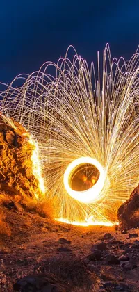 This fiery phone live wallpaper captures a stunning long-exposure photograph of a fire spinning in the air, showcasing its intricate details and mesmerizing beauty