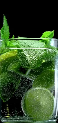 This phone live wallpaper showcases a close-up view of a refreshing glass of water with juicy limes and fragrant mint
