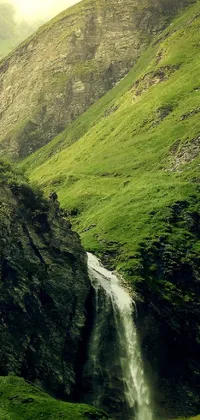 This live wallpaper depicts a breathtaking waterfall surrounded by lush vegetation in an idyllic valley