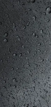 This phone live wallpaper features a stunning photorealistic image of droplets on a black surface